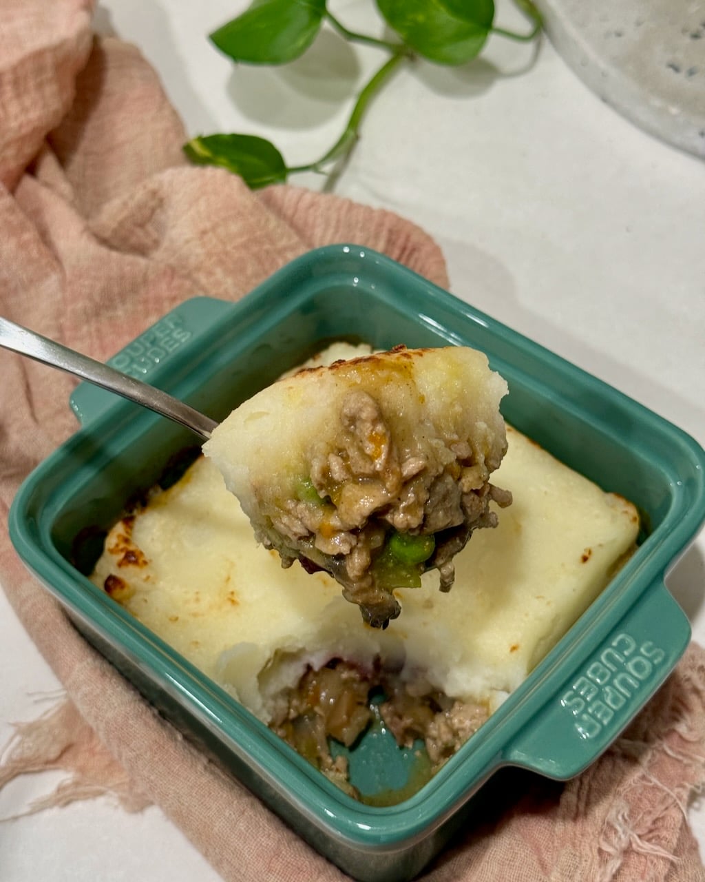 A scoop of turkey shepherd's pie from a single portion dish.
