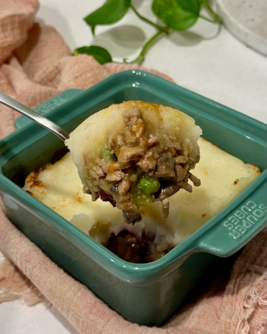 A scoop of turkey shepherd's pie from a single portion dish.